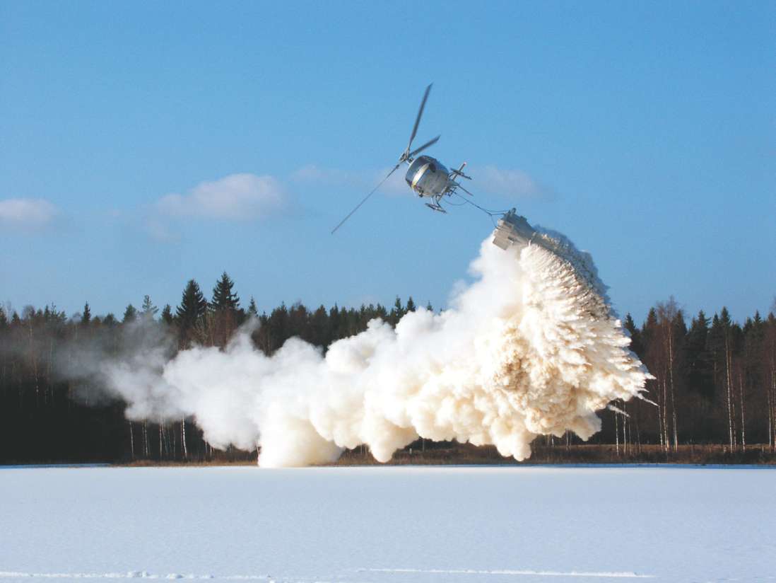 A photograph showing powdered limestone sprayed from a helicopter to reduce the acidity in a lake in Sweden.