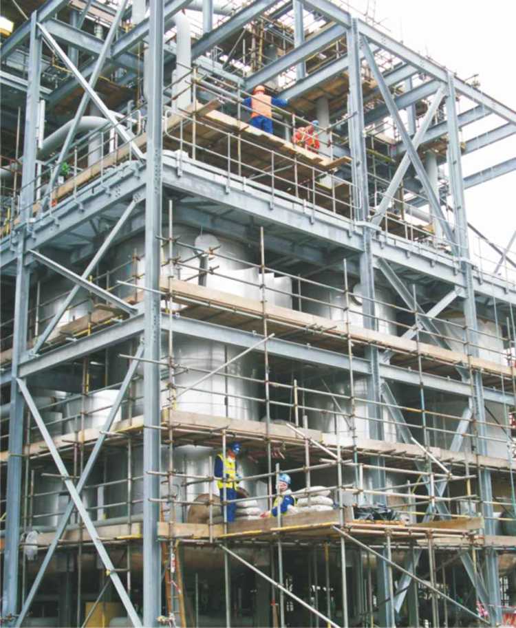 A photograph of an industrial plant in which ethanol is being purified using a molecular sieve.  Large tnks are being filled at their base with a zeolite.  The ethanol has been produced from wheat.