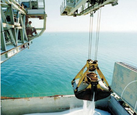 A photograph of purified bauxite being unloaded from a ship in Iceland, on its way to an aluminium extraction plant